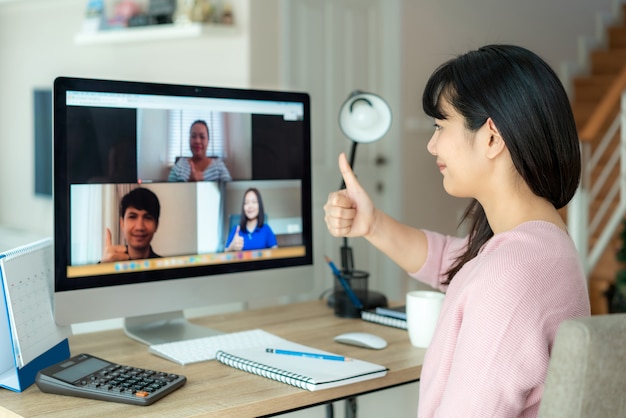 Asiatische Geschäftsfrau Daumen hoch zu ihren Kollegen über Plan in Videokonferenz