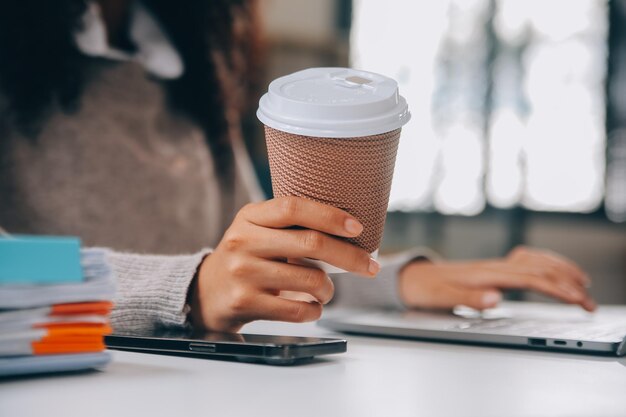 Asiatische Geschäftsfrau, die an einem Laptop arbeitet, sucht einen Job online, freiberuflich sucht und schreibt auf einem Notebook am Tisch, Lebensstil einer Frau, die online studiert