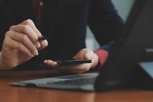 Asiatische Geschäftsfrau, die einen Laptop-Computer verwendet und im Büro mit einem Taschenrechnerdokument auf dem Schreibtisch arbeitet, um die Analyse des Finanzberichts-Geschäftsplan-Investitionsfinanzierungsanalysekonzepts zu planen