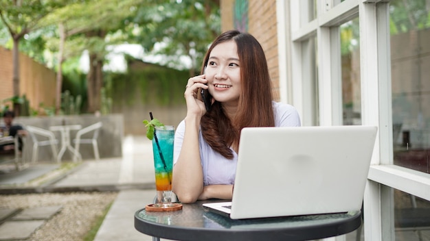 Asiatische Geschäftsfrau, die im Café anruft