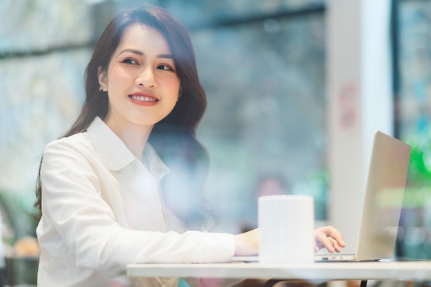 Asiatische Geschäftsfrau, die in einem Café arbeitet