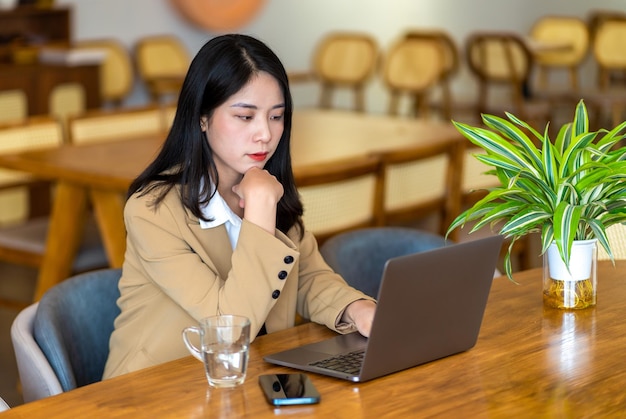 Asiatische Geschäftsfrau, die in einem Café arbeitet