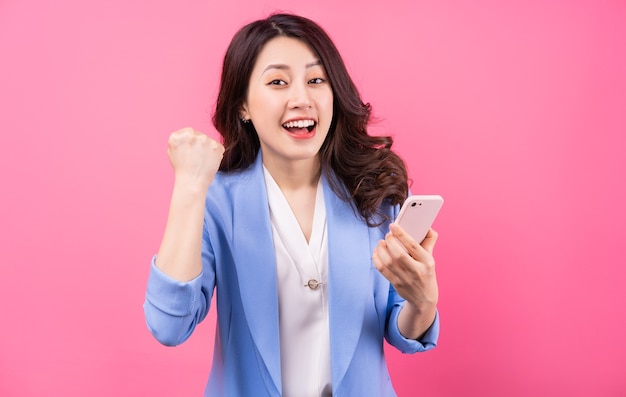 Asiatische Geschäftsfrau, die Smartphone auf Rosa verwendet