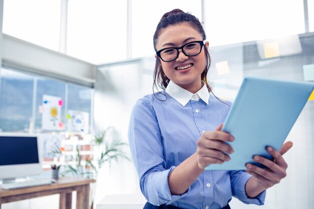 Asiatische Geschäftsfrau, die Tablette im Büro verwendet