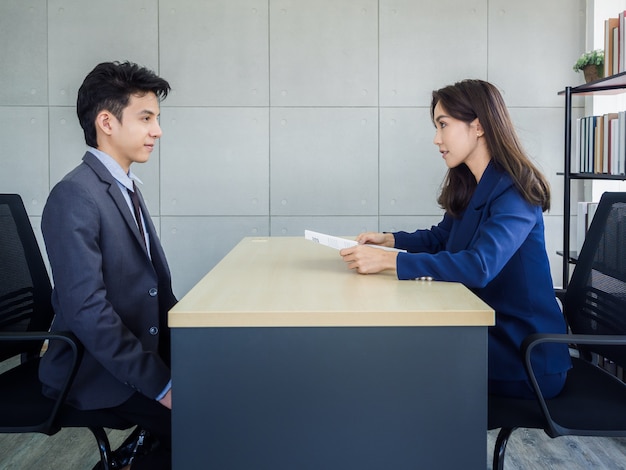 Asiatische Geschäftsfrau, HR-Überprüfung Lebenslauf des jungen asiatischen Geschäftsmannes im Anzug im Amt