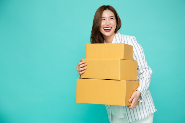 Asiatische Geschäftsfrau lächelt und hält Paket Paketkasten isoliert auf grünem Hintergrund