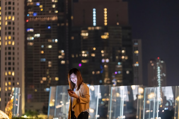 Asiatische Geschäftsfrau mit Smartphone mit Lächeln Aktion