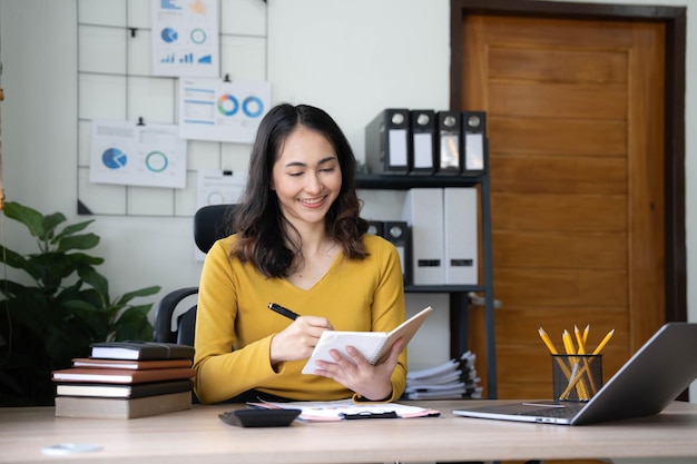 Asiatische Geschäftsfrau trifft sich im Büro und macht sich Notizen und benutzt ein Tablet im Büro