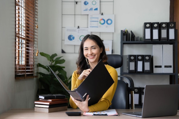 Asiatische Geschäftsfrau trifft sich im Büro und macht sich Notizen und benutzt ein Tablet im Büro