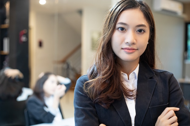 Asiatische Geschäftsfrauen und Gruppe, die Notizbuch verwendet