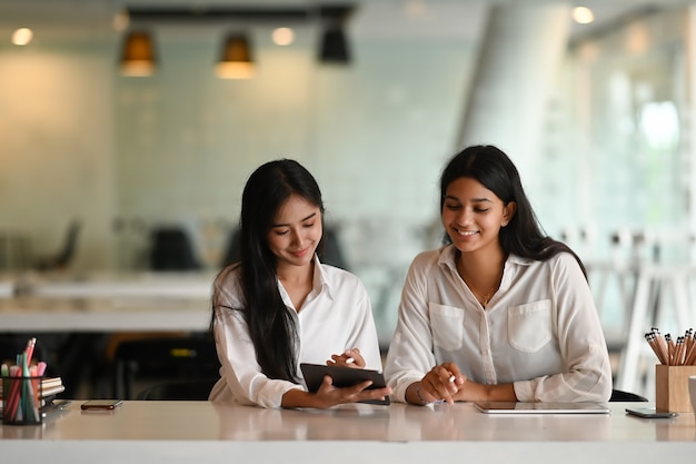 Asiatische Geschäftsleute arbeiten zusammen mit digitalem Tablet im Büro