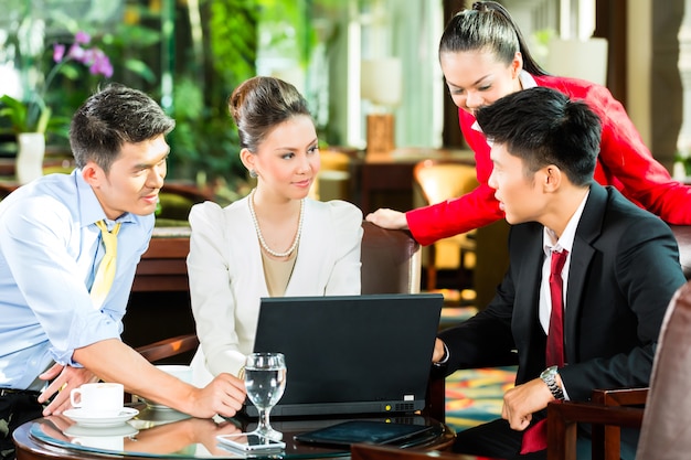 Asiatische Geschäftsleute bei der Sitzung in der Hotellobby