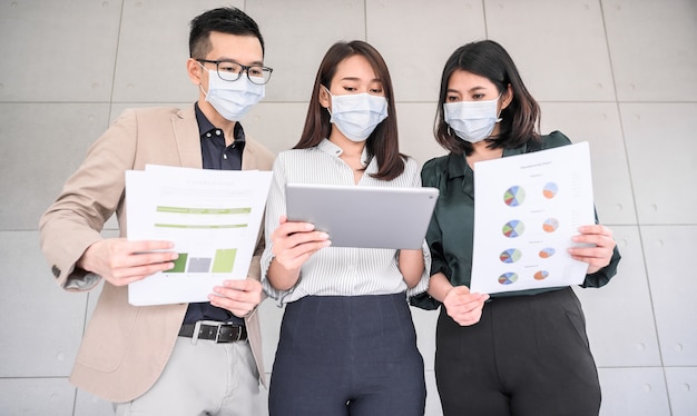 Asiatische Geschäftsleute tragen Gesichtsmaske diskutieren Projekt