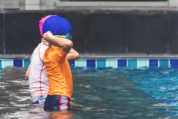 Asiatische Geschwister spielen im Schwimmbad