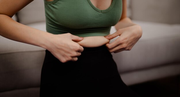 Asiatische gesunde Frau macht Diät Gewichtsverlust Schlanke Frau misst Taille mit Maßband nach Diät zu Hause Gewichtskontrolle