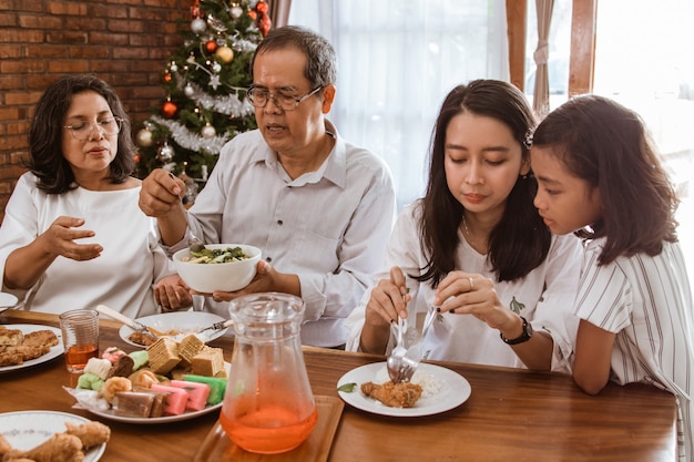 Asiatische glückliche Familie, die Weihnachten zusammen zu Hause feiert
