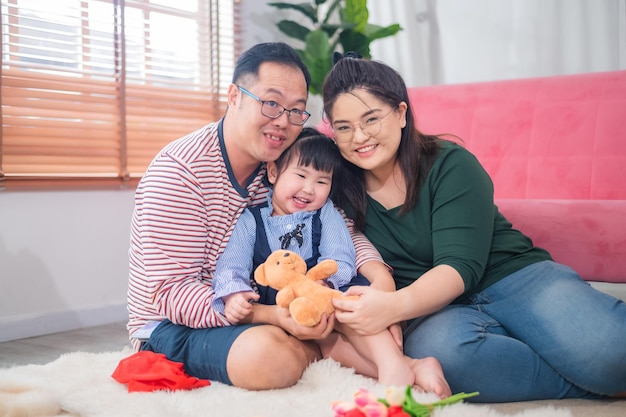 Asiatische glückliche Familie, die zu Hause Spaß hat