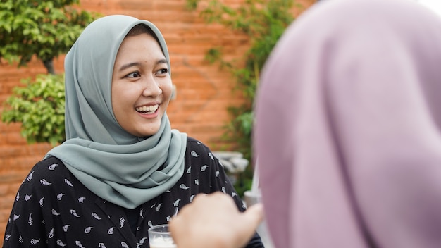 Asiatische Gruppe Hijab Frau, die im Café mit Freund lächelt