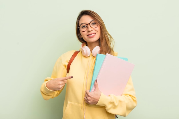 Asiatische hübsche Frau, die fröhlich lächelt, sich glücklich fühlt und zur Seite zeigt. universitätsstudentenkonzept