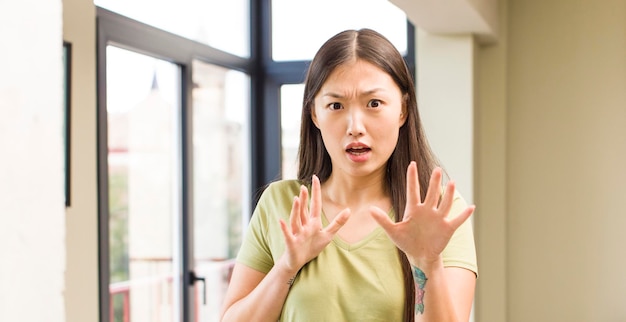 Foto asiatische hübsche frau zu hause mit großen fenstern im hintergrund