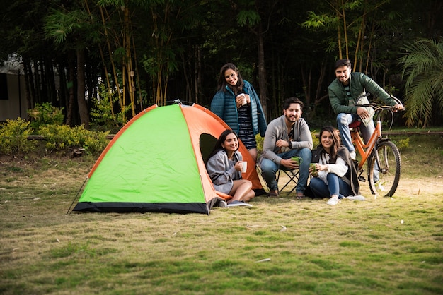 Asiatische indische junge Freunde haben eine gute Zeit auf Campingausflügen, erholsamen Urlaub mit lustigen Außenzelten