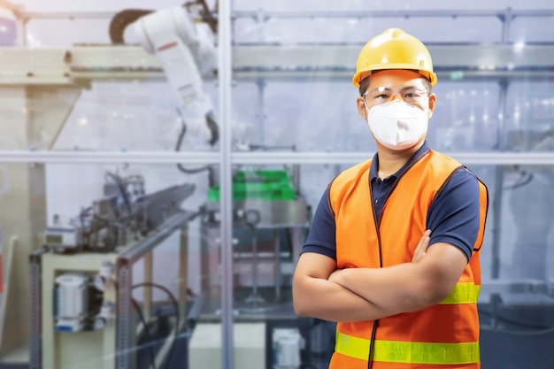 Asiatische Ingenieure oder Techniker tragen in der Fabrik einen Schutzhelm und eine reflektierende Weste