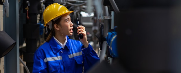 Asiatische Ingenieurin, die arbeitet und kommuniziert über Walkie-Talkie-Sender-Funkkommunikation Rooftoop modernes Gebäude in der Stadt urban