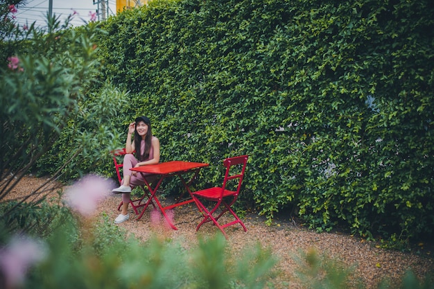 asiatische jüngere Frau, die im grünen Park sitzt