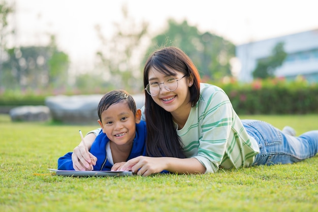 Asiatische Jugendliche unterrichten den Jungen liebevoll und Spaß