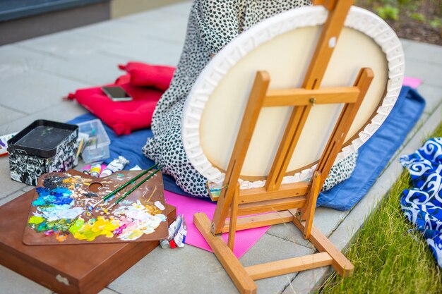 Asiatische junge Frau, die Bild in der Heimterrasse malt