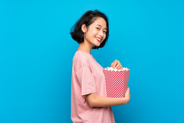 Asiatische junge Frau, die Popcorn isst