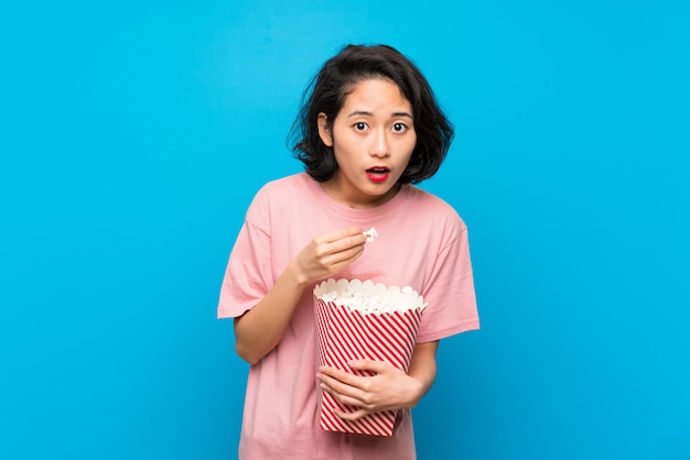 Asiatische junge frau, die popcorn isst