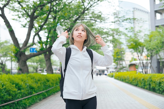 Asiatische junge Frau, die während der Übung hydratisiert