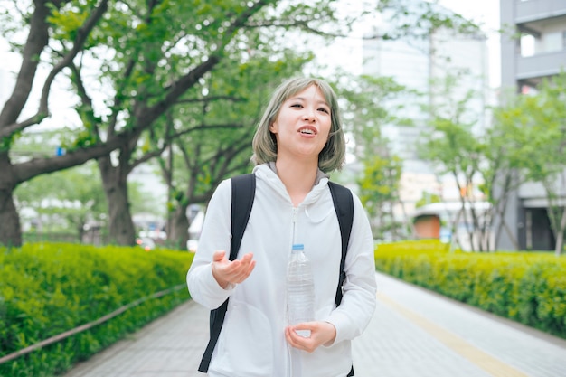 Asiatische junge Frau, die während der Übung hydratisiert