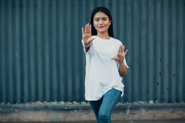 Asiatische junge Frau macht Qigong-Übungen im Sommer im Freien