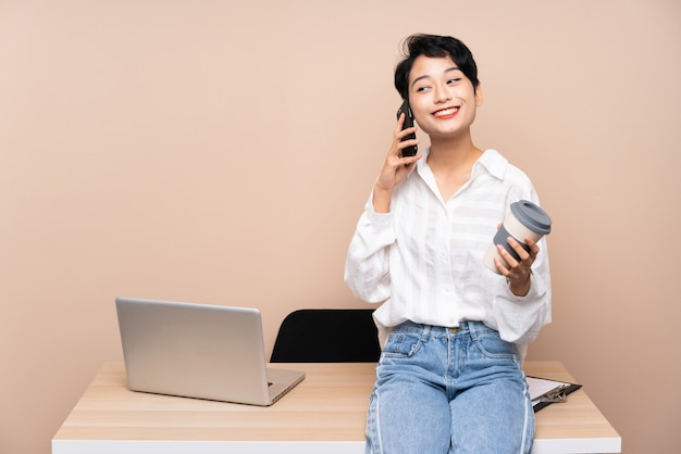 Asiatische junge Geschäftsfrau in ihrem Arbeitsplatz, der Kaffee hält, um zu nehmen