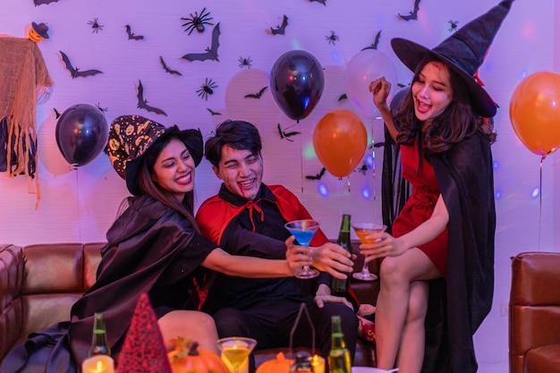 Asiatische junge Leute in Kostümen, die Halloween feiern Gruppe, die sich auf einer Party im Nachtclub amüsiert