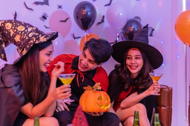 Asiatische junge Leute in Kostümen, die Halloween feiern Gruppe von Freunden, die sich auf der Party im Nachtclub amüsieren