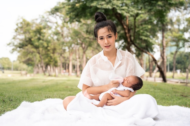 Asiatische junge schöne Mutter, die ihr Neugeborenes hält