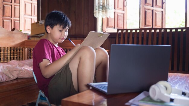 Asiatische Jungen üben während der Schulferien zu Hause in ihrer Freizeit Bleistiftzeichnungen Kid Creators