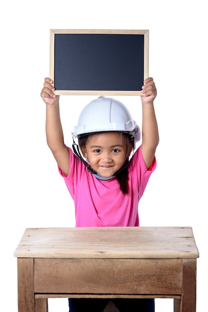 Asiatische Kinder, die Schutzhelm tragen und mit der Tafel lokalisiert auf weißem Hintergrund lächeln. Kinder und Bildungskonzept