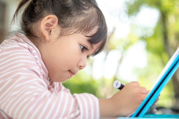 Asiatische Kinder lernen im Klassenzimmer zu zeichnen.