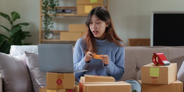 Asiatische KMU-Geschäftsfrau, die zu Hause im Online-Shopping-Konzept arbeitet
