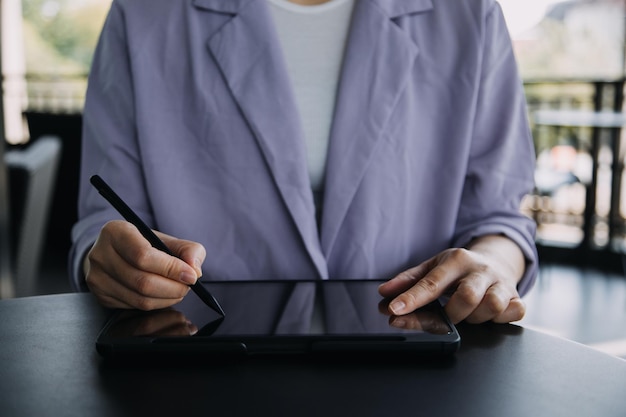 Asiatische Kollegen Mann und Frau diskutieren und arbeiten mit Laptop-Computer auf dem Schreibtisch im Büro