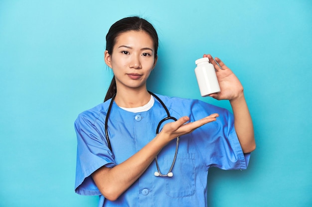 Asiatische Krankenschwester mit einer Pille-Flasche Studio-Schuss