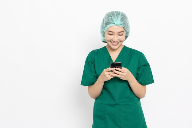 Asiatische Krankenschwester- oder Doktorfrau, die den Handy lokalisiert über weißem Hintergrund verwendet