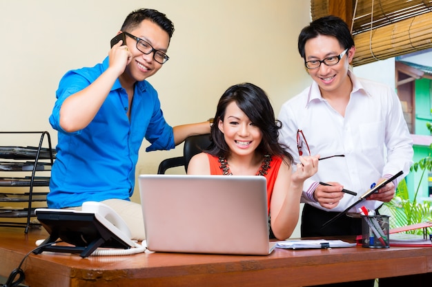 Asiatische Kreativagentur, Teamsitzung in einem Büro mit Laptop