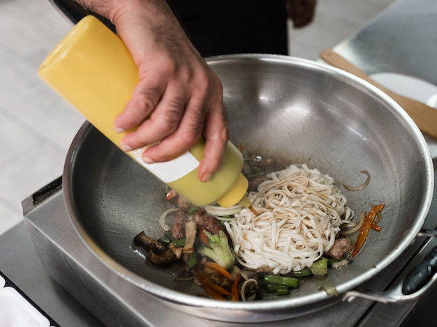 Asiatische Küche Mahlzeit in einem Restaurant. Fleisch- und Gemüsegericht kocht im Wok