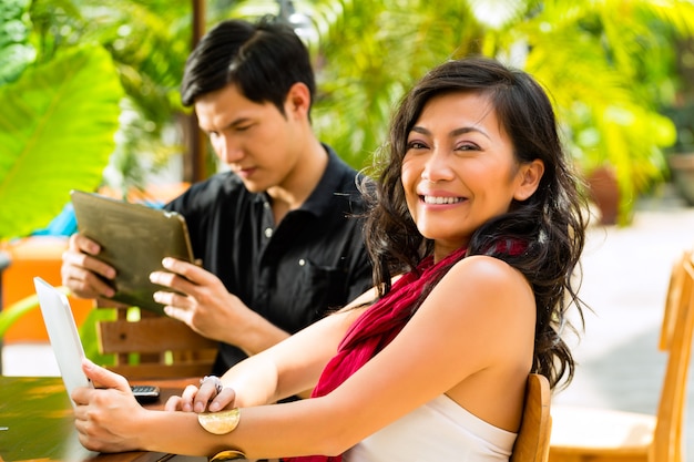 Asiatische Leute im Café mit Computer