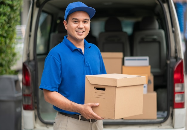 Asiatische Lieferung in blauer Uniform mit Paket